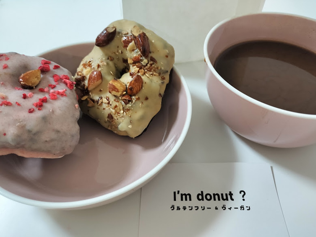 お皿に乗ったドーナツ2つとコーヒー。おしゃれなティータイム。