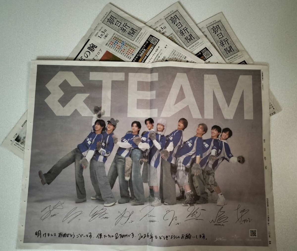 2026年1月3日の朝日新聞に掲載された&TEAMの一面広告が複数部重ねられている様子。