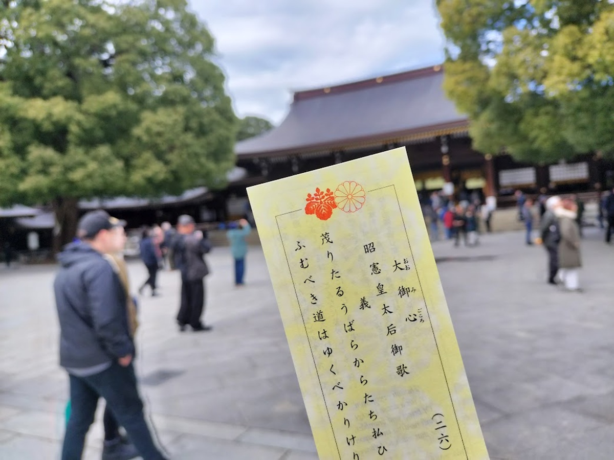 明治神宮の本殿前で引いたおみくじ「大御心」を手に持つ様子